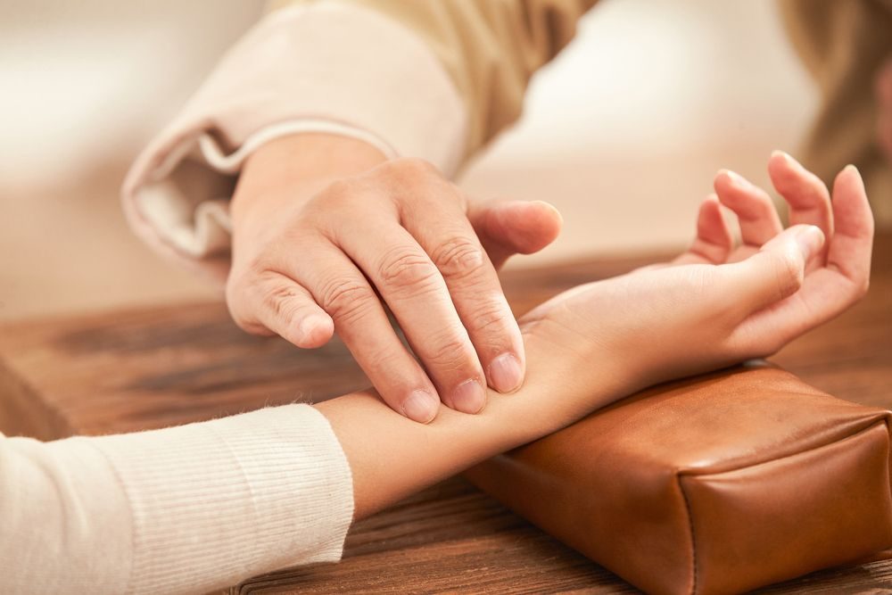 Therapist checking a guest's pulse during an Ayurvedic consultation