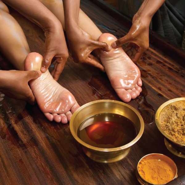 Therapist performing an Abhyanga warm oil massage
